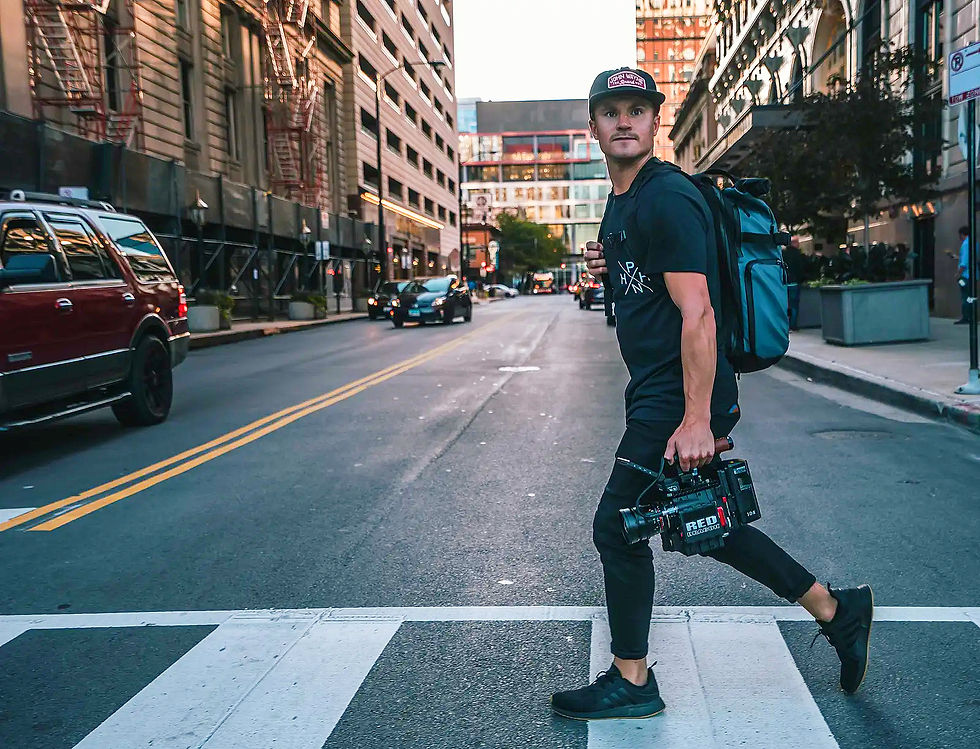 Mann mit Outdoor Rucksack und Kameraausrüstung überquert Straße.