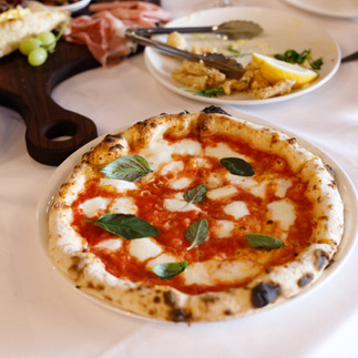 Sneaky's Margherita Pizza with a tomato base, fior di latte, and basil