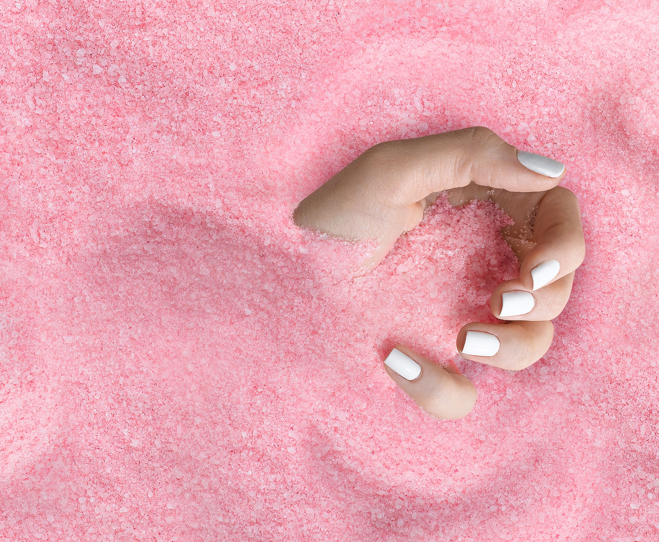 A hand holding pink sugar
