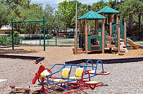 A playground with a swing set and jungle gym