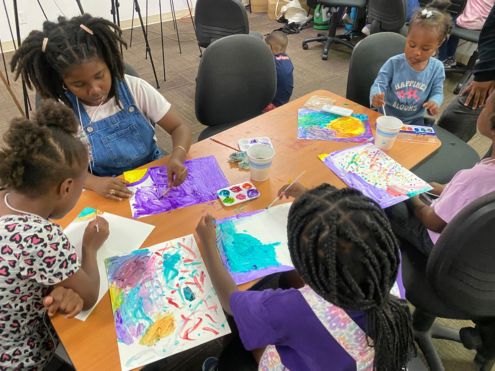 Children paint vibrant artwork together
