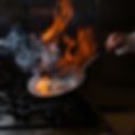 side-view-mushroom-frying-with-smoke-fire-human-hand-pan.jpg