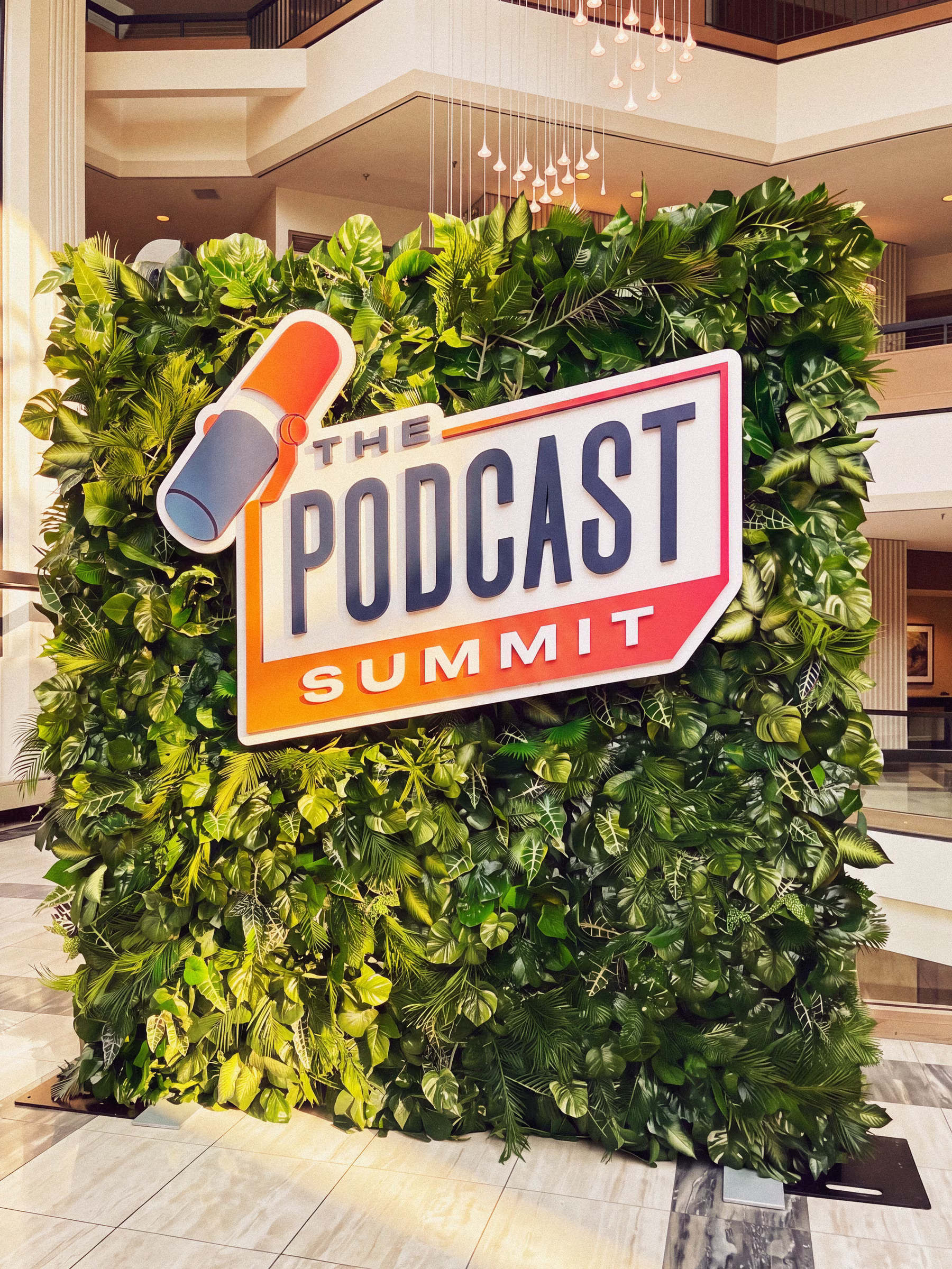 The Podcast Summit branded greenery wall