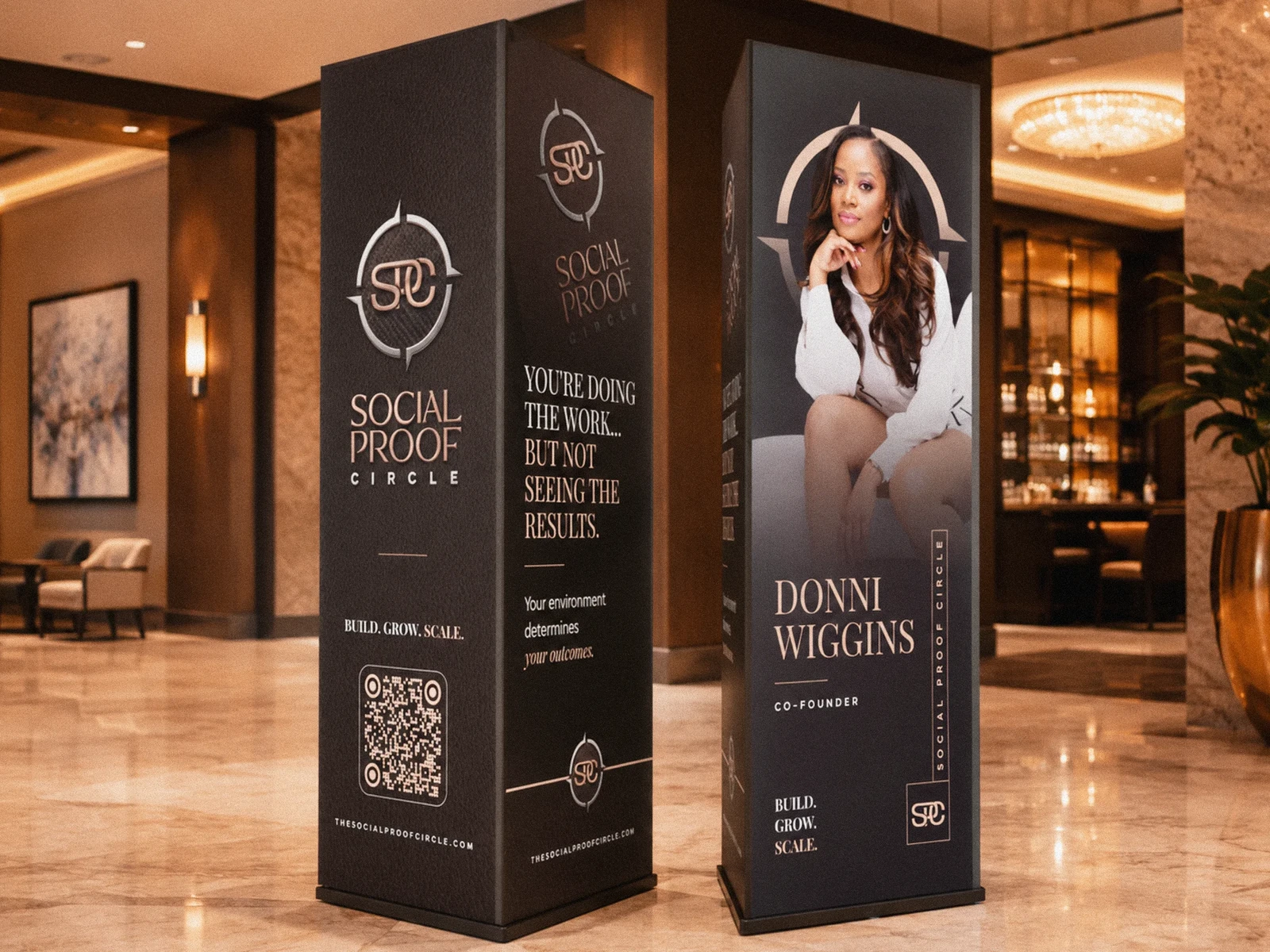 Social Proof Circle standing event displays featuring its branding and Donni Wiggins.