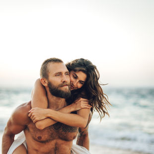 candid photo of a piggyback ride on the beach