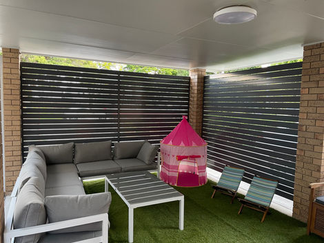 Outdoor living area with slats to enclose the carport space