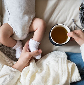 Unrecognizable mother with newborn baby son lying on bed.jpg