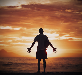 A man praying on the beach during the su