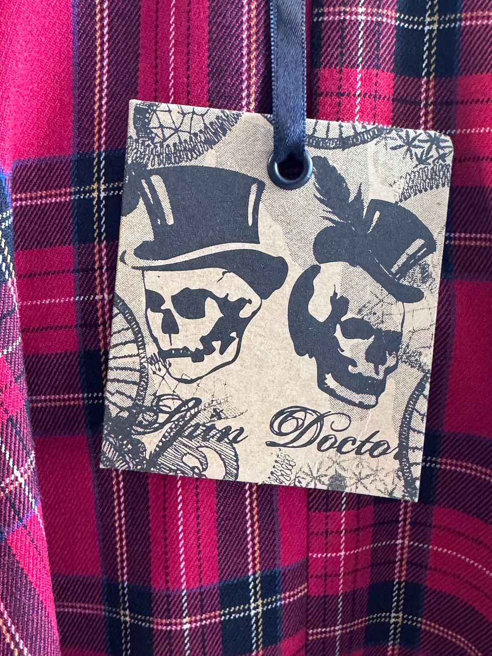 Thumbnail: Spin Doctor brand tag with skulls on red tartan skirt