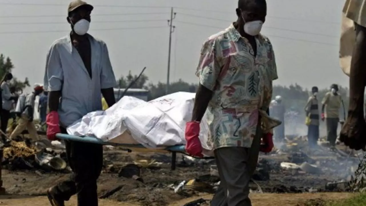 Des volontaires tranportent les corps des victimes du massacre à Gatumba. Le 14 aout 2004 (SIMON MAINA/AFP)