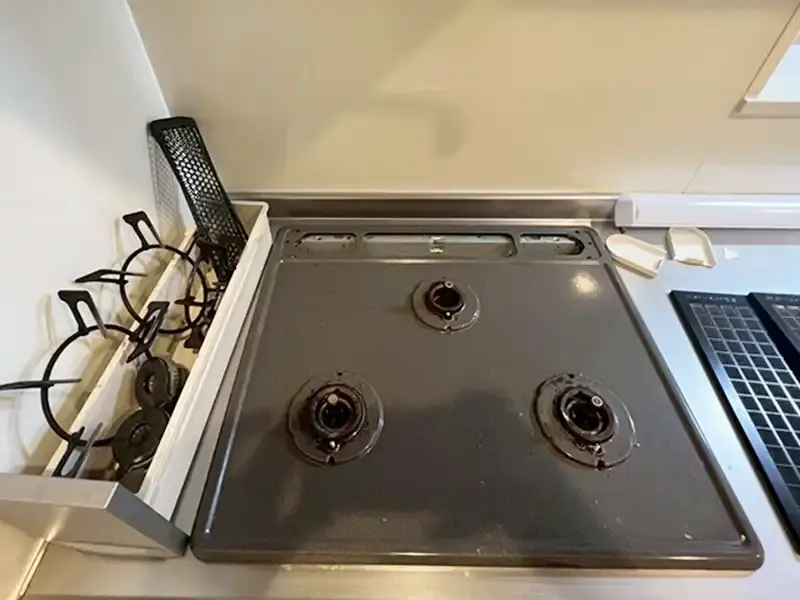 埼玉県川越市の1K空室、ガスコンロ清掃前の様子。焦げ付きや油汚れが目立つ状態です。