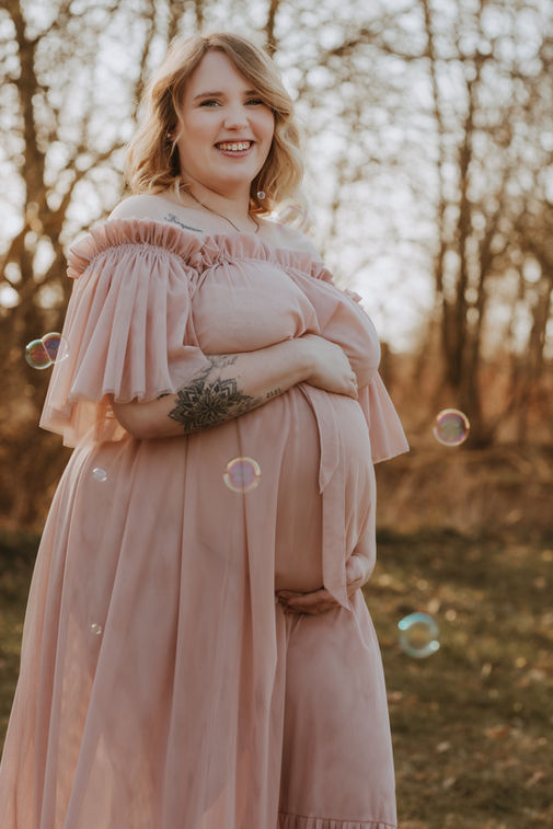 Babybauchshooting in der Natur bei Lübeck im warmen Tageslicht