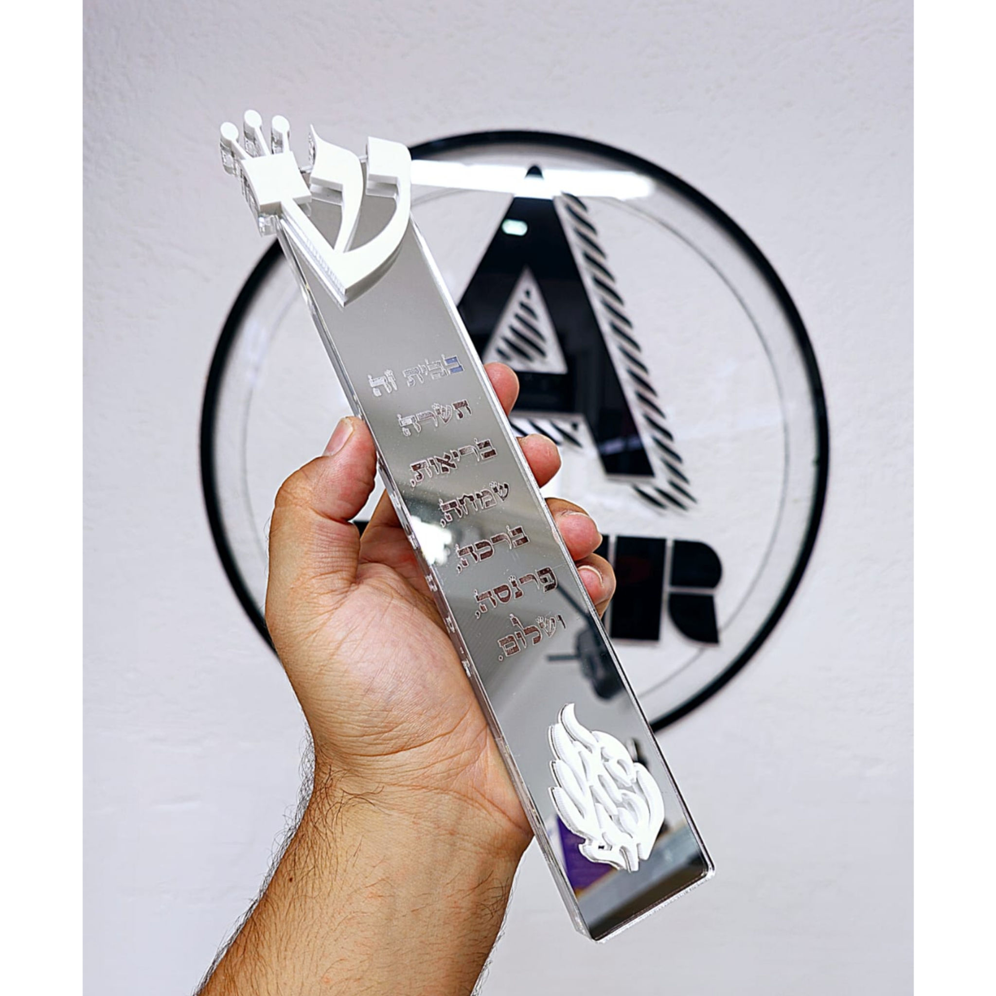 Modern silver Mezuzah case held by a hand