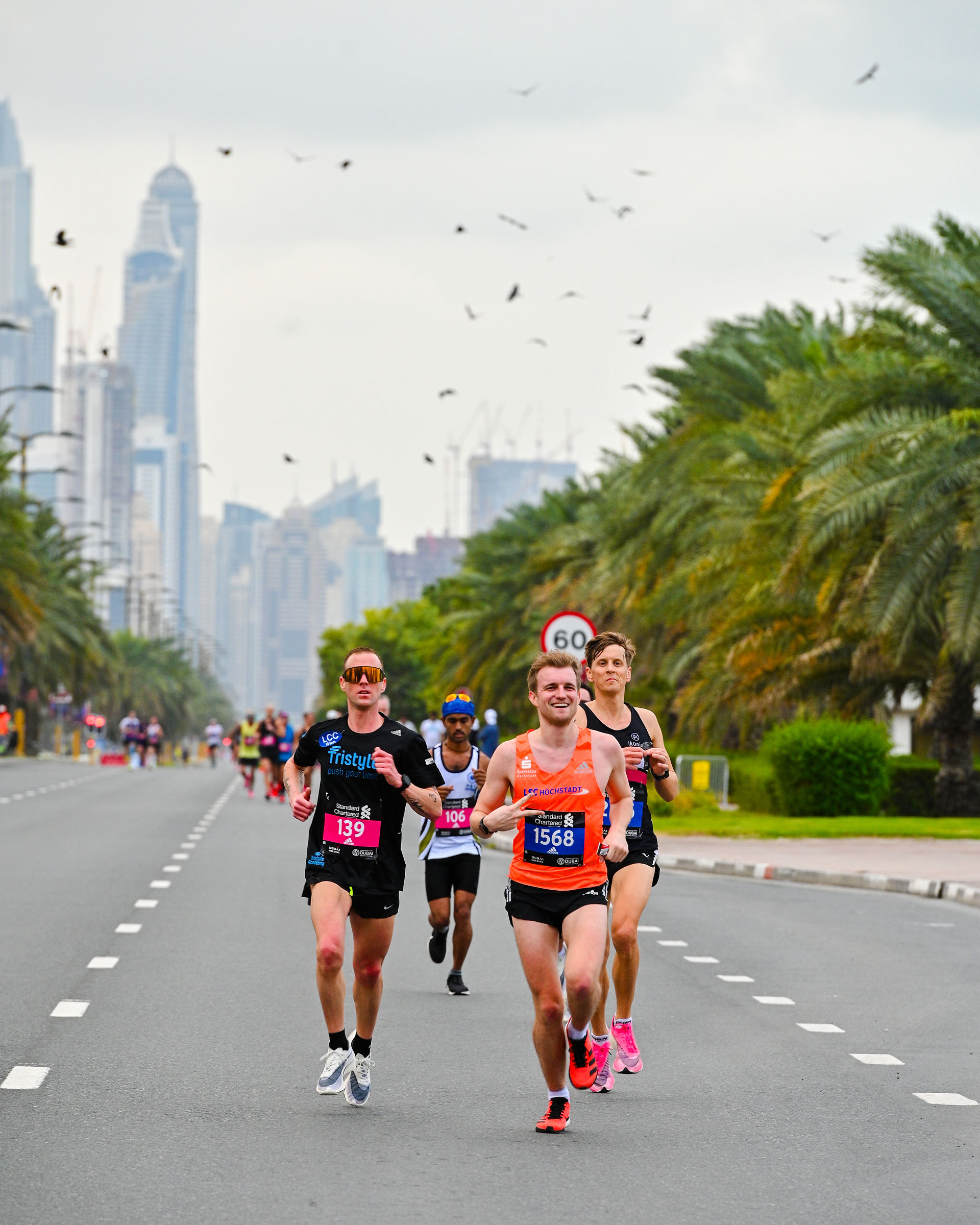 Runners participating in Dubai city marathon, with city skyline in background 