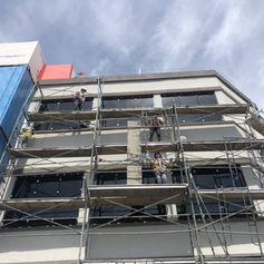 View of workers applying stucco on the exterior walls of a building