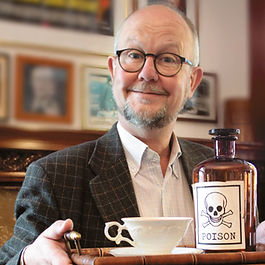 Autor Ralf Kramp mit einem Gifttablett in einem Wohnzimmer