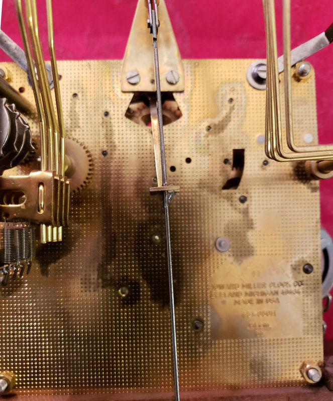 Lacquer damage and contamination buildup caused by oil migration inside a clock movement. Over time, softened lacquer, dust, and degraded lubricant may harden around bushings and pivot areas, increasing friction and wear.