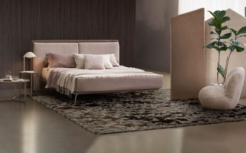 Ambijent spavaće sobe sa krevetom od štofa minimalistički dizajn i foteljom za dodatnu udobnost