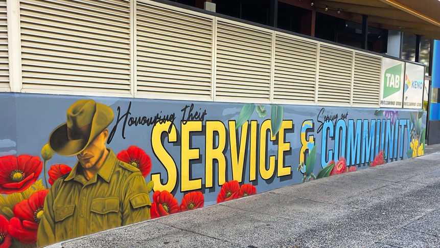 Bold hand lettered Anzac tribute mural reading Service and Community on RSL facade Miranda