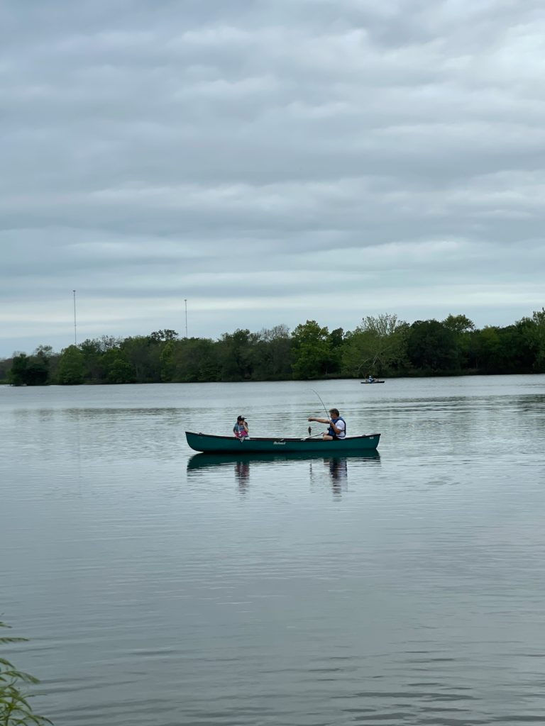 A dad and his young daughter paddle and fish along a body of water in Texas.