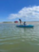 A family paddles along in shallow water.