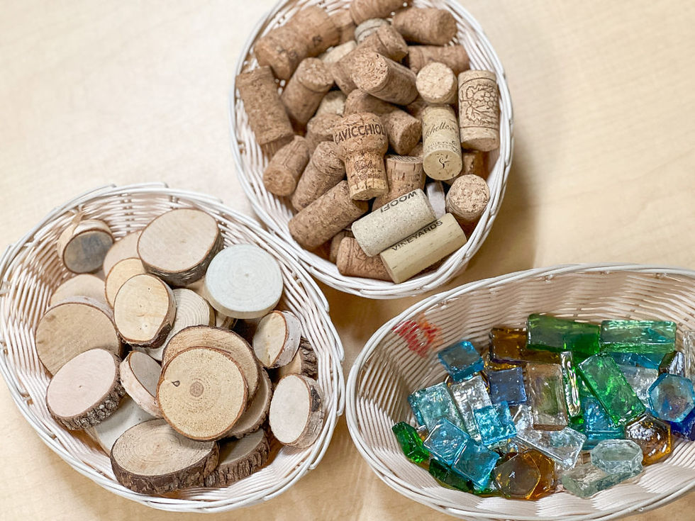 Several baskets on a table featuring natural products like sea glass and wine corks.