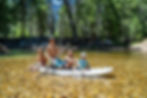 A family paddle boarding together in the summer.