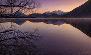 Mountain range reflected in still water at Lake Pearson, Canterbury, New Zealand