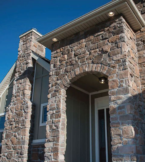 rustic and beautiful entryway to a home adorned with stone veneer