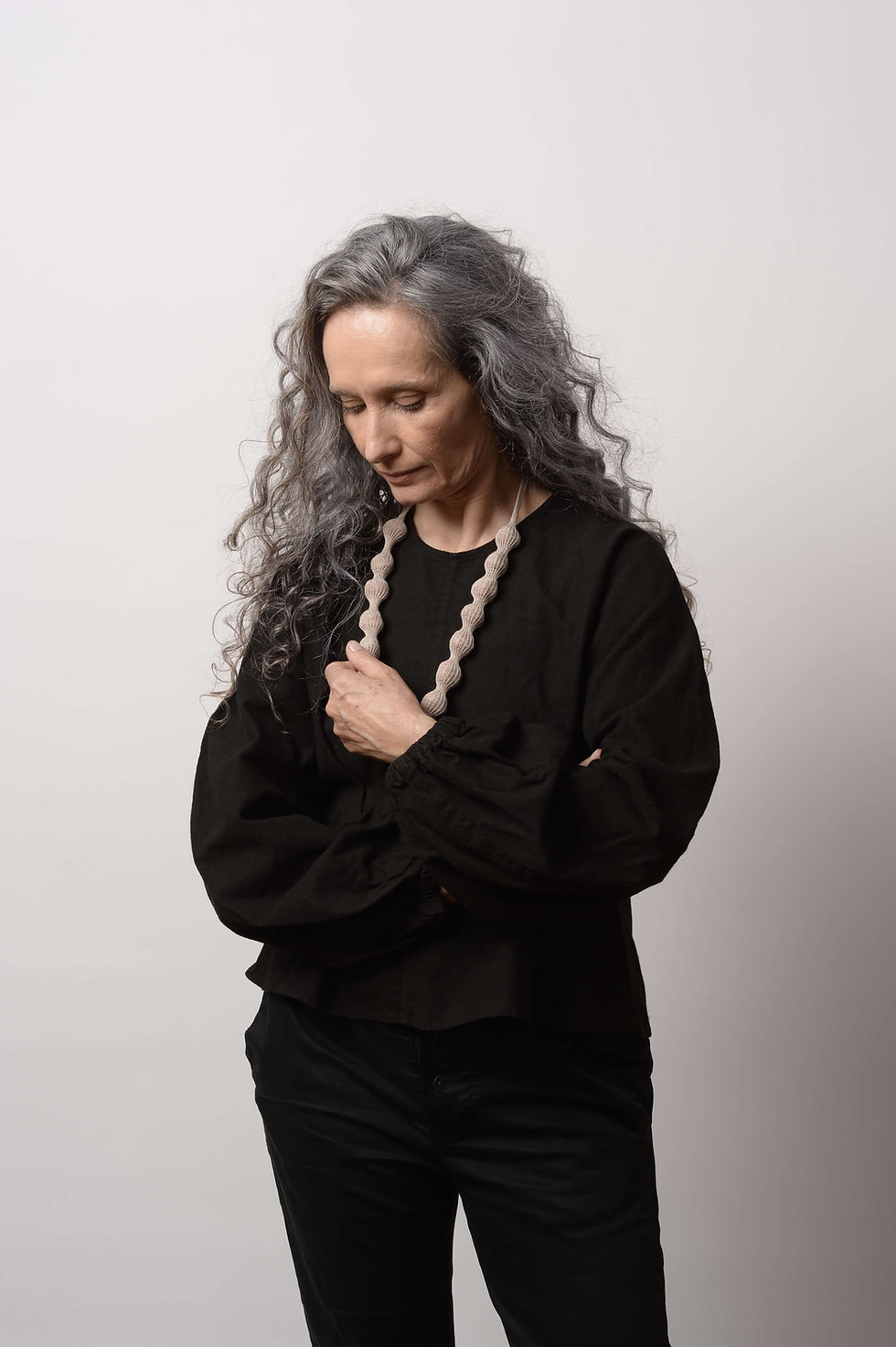 אשה עם שרשרת מחומרים טבעיים