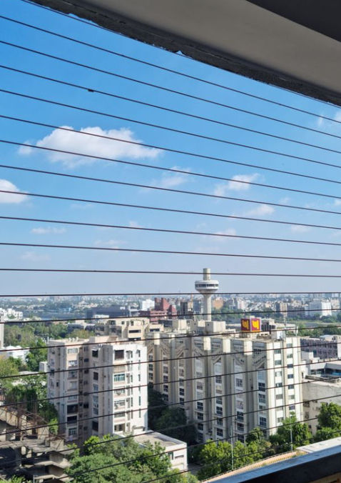 Invisible balcony grills in Thane residential tower, ensuring kids’ safety with sleek, durable design and a clear view of the city.