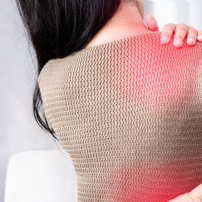 Person in a beige sweater holding their shoulder with a red glow indicating pain. The setting is minimalistic and neutral in tone.