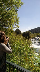a person takes a photo of a waterfall