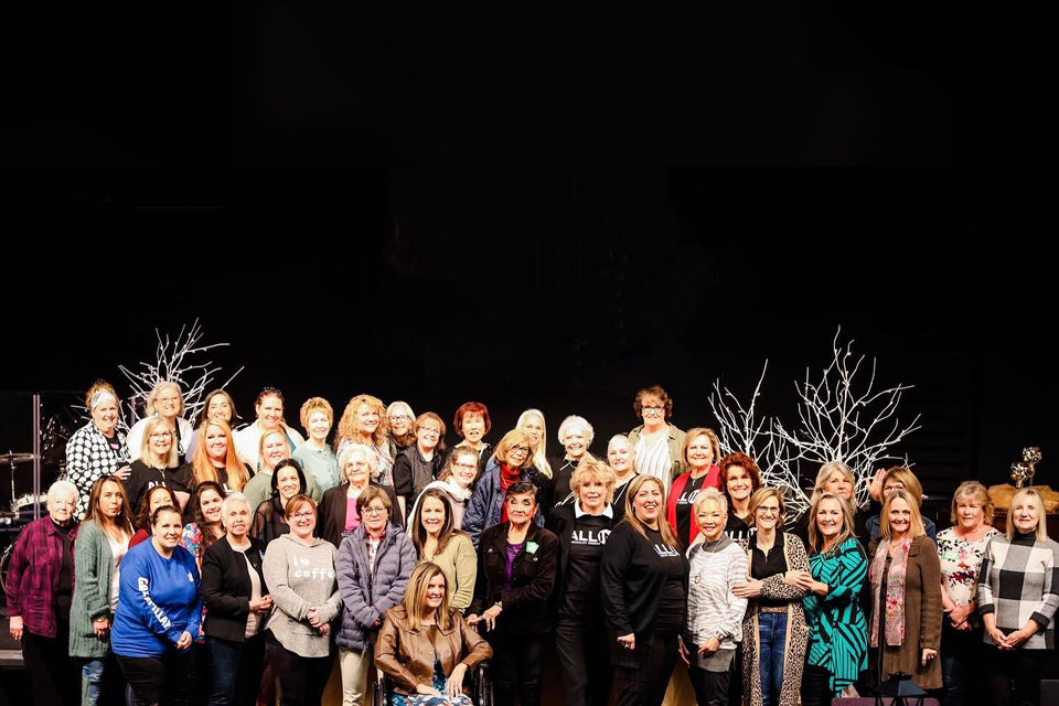 Women posing on the stage for a picture after a women's church event
