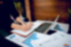 homem-de-negocios-que-trabalha-em-um-escritorio-computador-e-graficos-em-sua-mesa-ideias-d