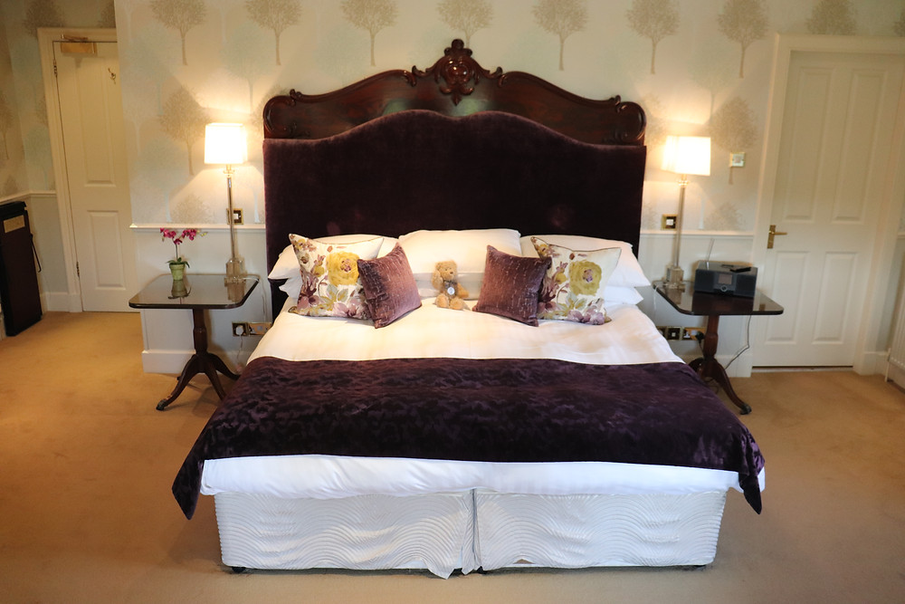 King sized bed with purple furnishings and a teddy bear at rufflets hotel st andrews scotland