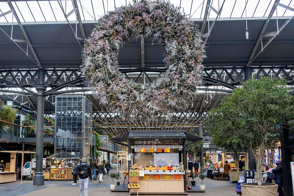 Entrance to a Victorian market with a large wreath hanging from the ceiling.
