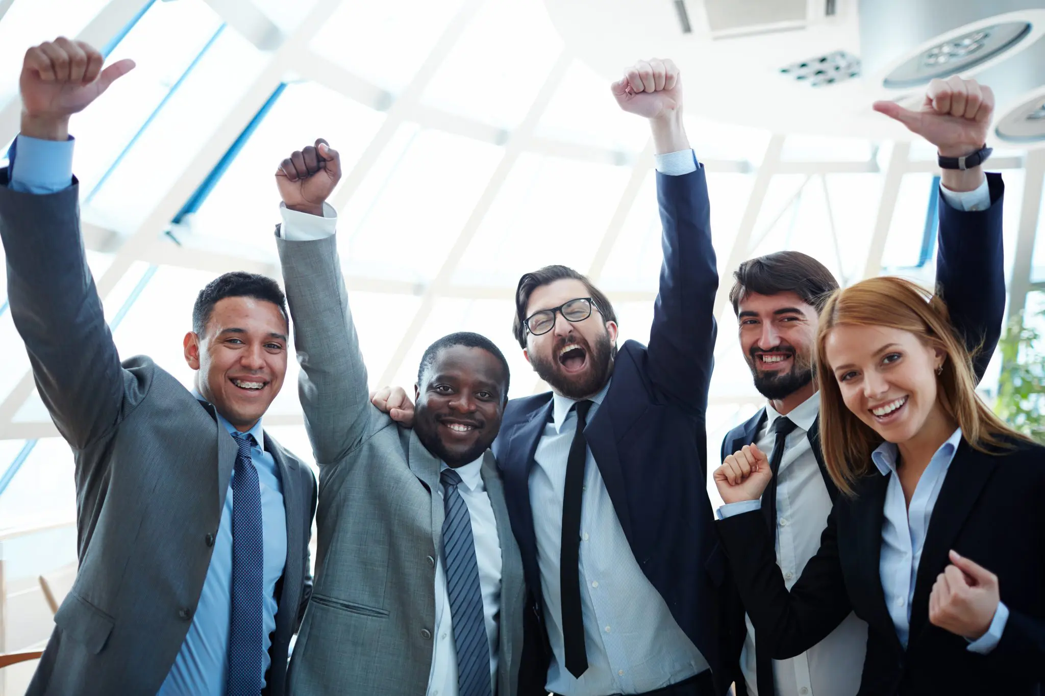 Happy car salespeople with fists in air