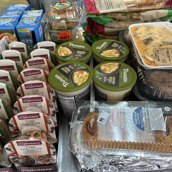 Various packaged food items including pies, soups, cakes, and snacks. Helping Hands approved.