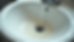 Eye-level view of a bathroom sink with soap scum and mineral stains