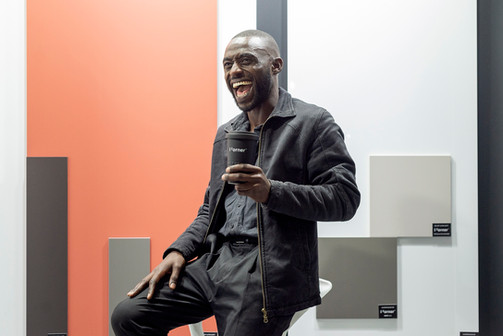 Lachende man met 'Interzum' kopje voor 'FURMT' productstalen.