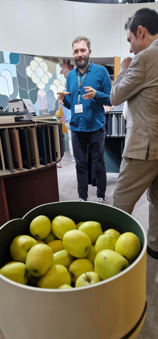 Gele citroenen in emmer, mensen praten bij productdisplays.