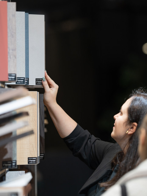Vrouw kiest materiaalstalen, kijkt aandachtig naar Forner panelen.