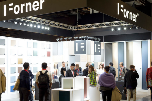 Bezoekers bekijken moderne displays op een drukke beursstand.