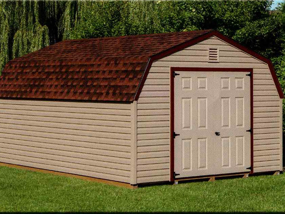 12x16 Mini Barn vinyl storage building with red roof shingles, beige vinyl siding, white 6-panel double doors, and burgundy trim set on grass with trees in background
