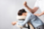 Side view of masseur massaging woman back with elbow, sitting on massage chair on white ba