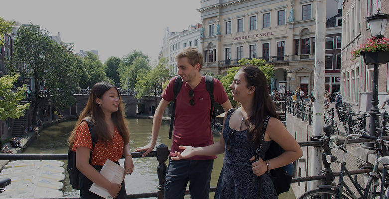 International students on a canal bridge in Utrecht. Utrecht University is a client of Azorus CRM for student recruitment.