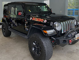 front passenger side exterior view of all black jeep wrangler, post detail, paint correcti