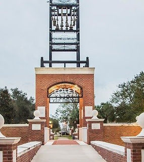 This is the Foley Clock Tower located in downtown Foley, AL. The photo was taken from the walkway leading to the clock tower, so a portion of the concrete walkway and brick details are also included.