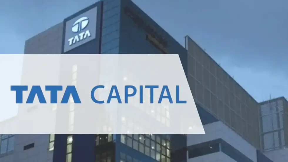 Blue-lit building with Tata logo and glass facade. "TATA CAPITAL" text in bold blue letters overlays the image. Evening sky in the background.